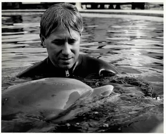 Bob Bailey in the water alongside a dolphin
